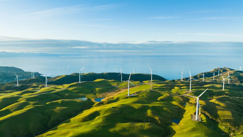 Existem muitas turbinas eólicas em funcionamento nas montanhas à beira-mar