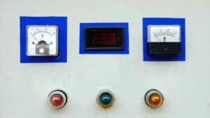 Control panel with analog voltmeter, digital voltage meter, ammeter, and red, green, yellow indicator lights below.