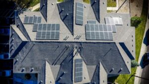 Aerial view of a residential rooftop with multiple solar panels installed, promoting renewable energy solutions for homes and eco-friendly living.