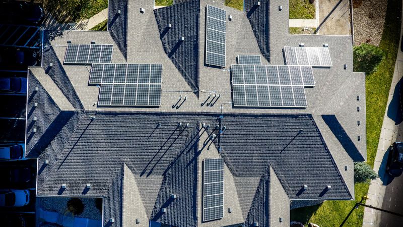 Aerial view of a residential rooftop with multiple solar panels installed, promoting renewable energy solutions for homes and eco-friendly living.